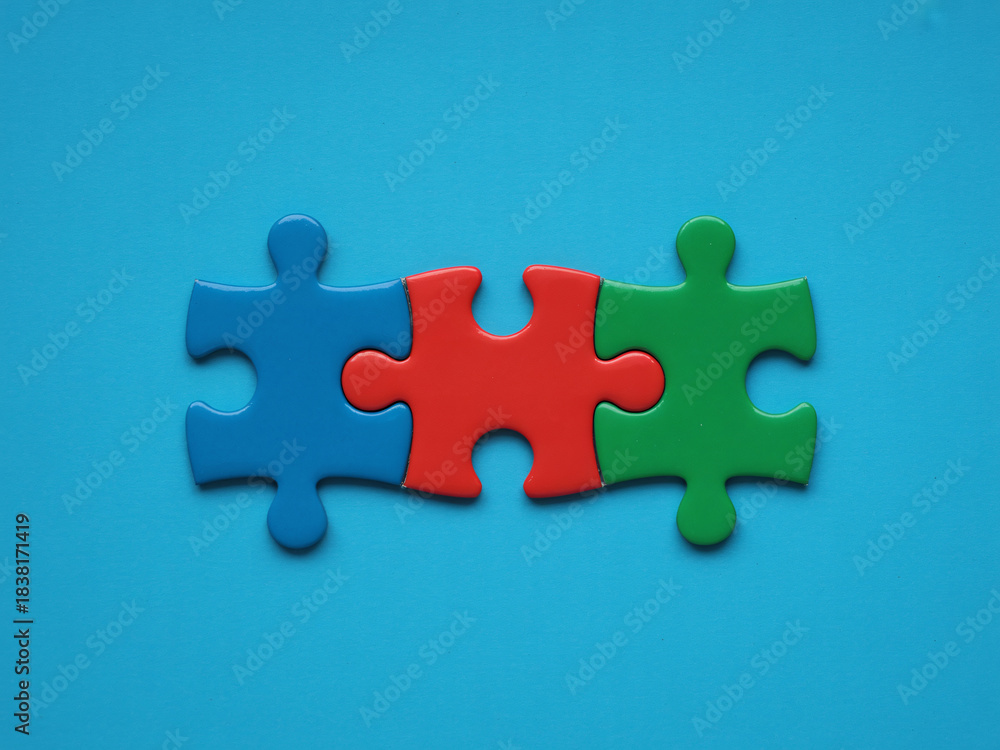 Fototapeta premium Three vibrant puzzle pieces connect perfectly demonstrating teamwork success and essential business solutions integration
