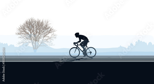 Silhouette of cyclist on road with lone tree in misty landscape background
