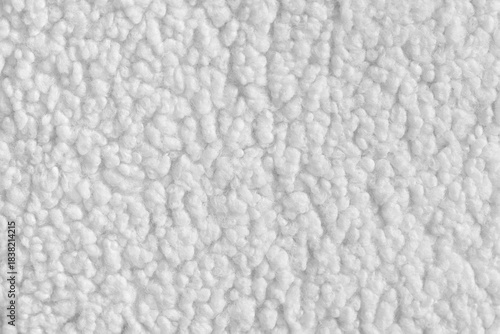 Vibrant white color fabric texture of soft faux fur cloth with fluffy surface, abstract background. Close up, macro of shaggy fabric texture, upholstery material, textile backdrop