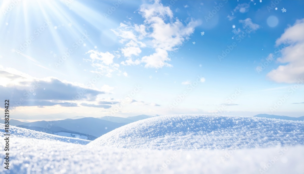 Obraz premium Peaceful winter scene featuring snow-covered hills under a bright blue sky with sunlight and clouds.