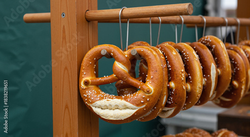 Freshly baked pretzels hanging on rack at outdoor market  