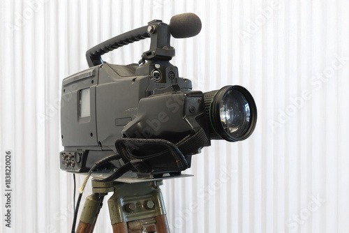 Old studio video camera on tripod, ion white background