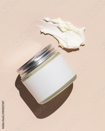 Jar of beef tallow skincare with texture product swipe on tan background