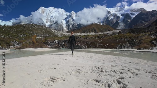 Person overlooking an immense mountain and glacial river. Remote trekking view in Manaslu trek, Nepal. Wide shot.