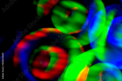 Wallpaper Mural Vivid green, red and blue glowing circles drift across a deep black background, forming an abstract composition of blurred motion, overlapping light shapes and smooth color transitions Torontodigital.ca