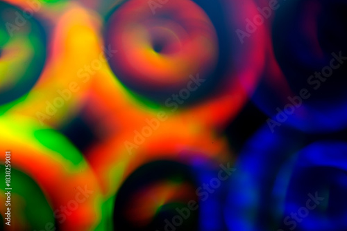 Wallpaper Mural Blurred spirals of red, green, blue and yellow light overlap on a dark background, creating a vivid abstract motion filled with glowing circles and smooth flowing color gradients Torontodigital.ca