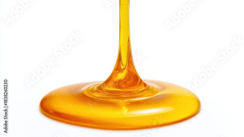 A golden liquid flows from a high point and spreads across a flat surface below. The liquid has a smooth texture and a shiny appearance