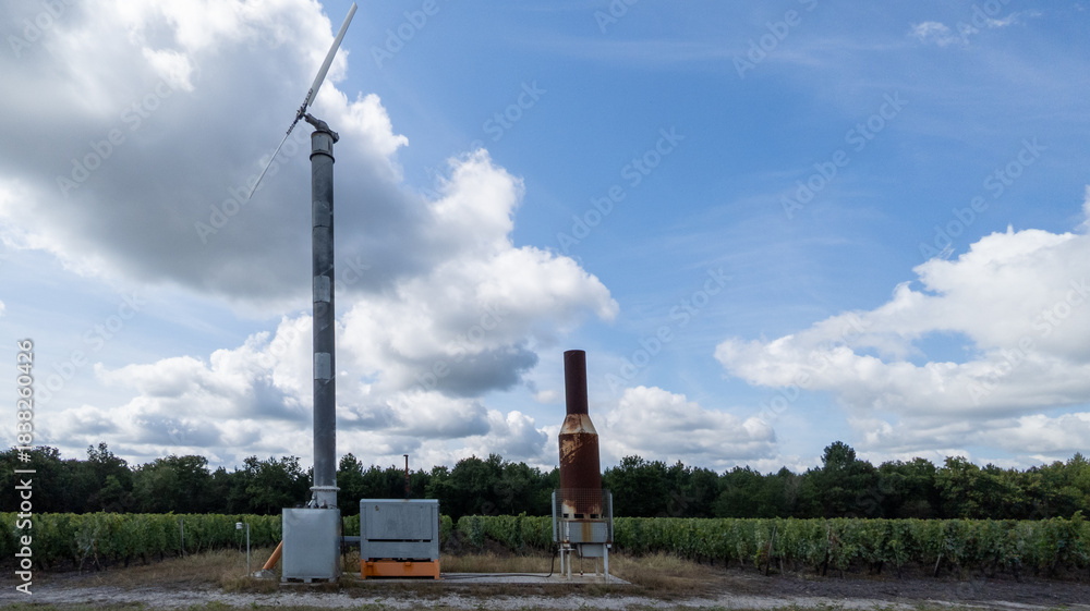 Naklejka premium frost fan wind machine frost protection tower for crops in bordeaux french vineyard