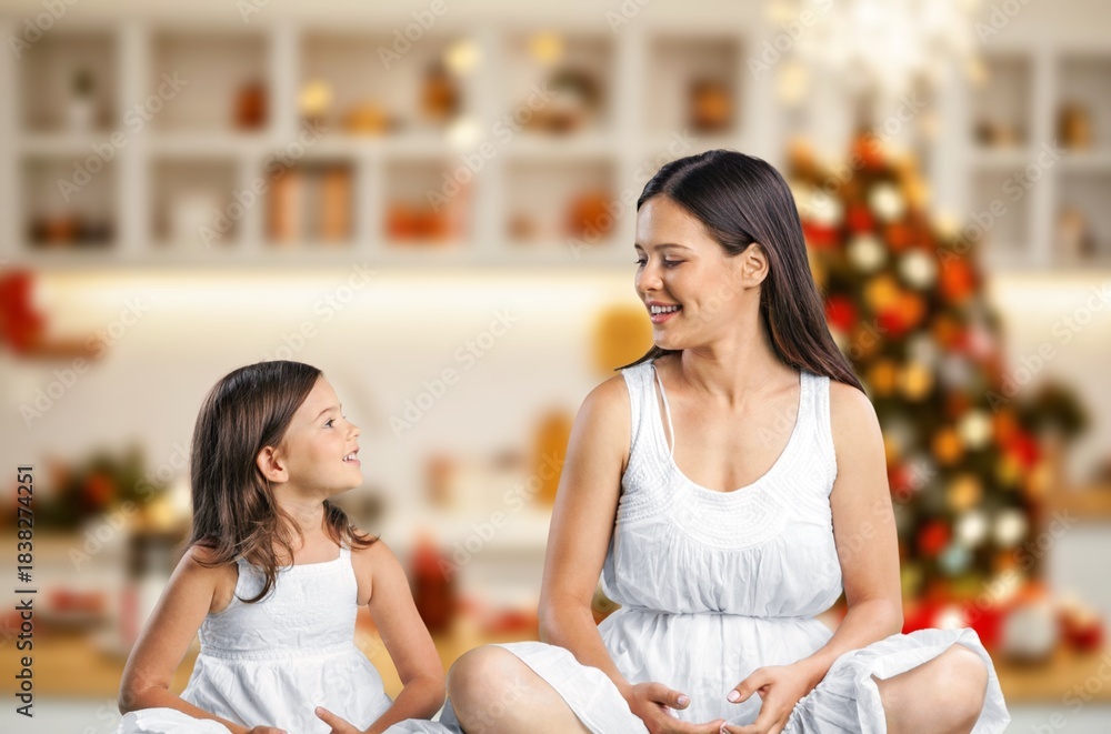 Fototapeta premium Healthy mother and girl doing yoga at christmas morning