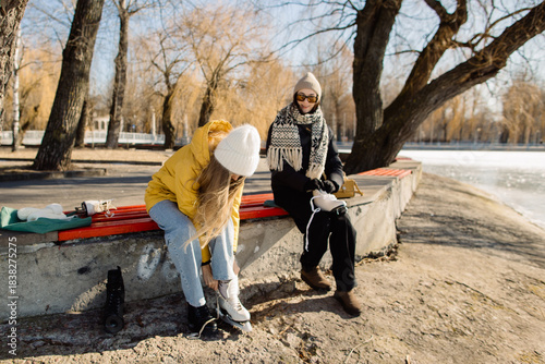 Friends preparing for ice skating on frozen lake