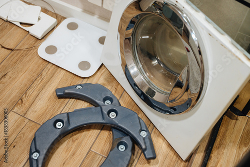 Disassembled washing machine with exposed parts during repair, showing appliance diagnostics.