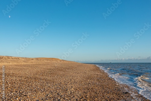 deserted beach at Browndown Hampshire England with blue sky in the background
