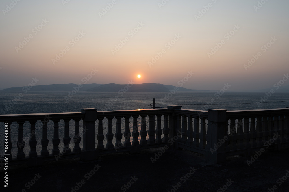 Obraz premium View from a terrace with column railing to the sea at sunset