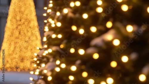 Decorative Christmas Tree with Bright Lights in Urban Square During Snowfall at Night