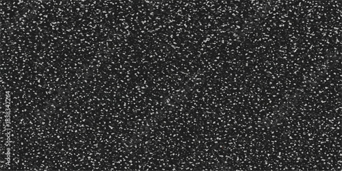 A dark and rough black asphalt road texture featuring an abstract bitumen pattern on a gritty stone surface material provides a detailed grey construction wallpaper for a street background