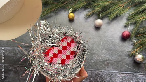 Close-up of hands opening a white gift box with a red bow. There is a pink heart inside. new year concept