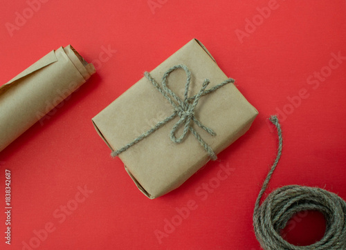 Packing of New Year's gifts Gift, twine, paper on a red background.