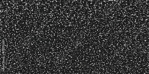 Abstract closeup of a rough dark tarmac surface featuring a textured black and white asphalt pattern with grainy stone details and grey bitumen material for a street road wallpaper background