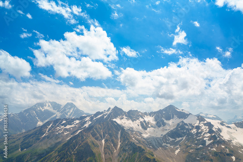 Mountain landscape with glacier and snow-covered peaks under blue sky