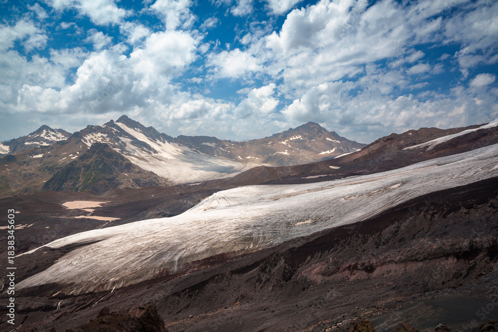 Obraz premium Mountain landscape with glacier and snow-covered peaks under blue sky