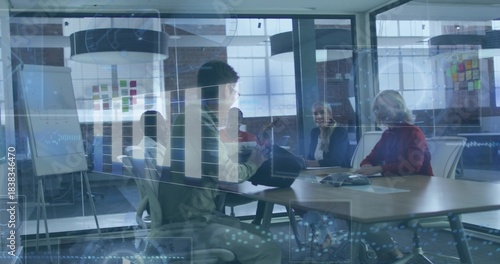 Discussing plans team sitting at glass-walled table in business attire and red sweater with laptop