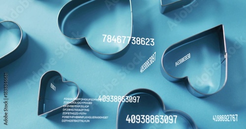 Displaying cluster of metal heart cookie cutters resting on blue tabletop, with white labels
