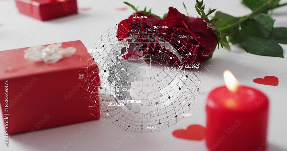 Fototapeta premium Displaying red rose lying on white tabletop, red gift box, lit candle, digital globe overlay