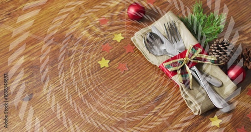 Displaying utensil bundle in beige napkin on wooden tabletop, silverware, plaid ribbon, copy space