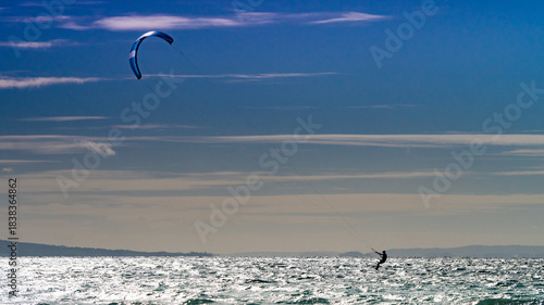 Kite surfer riding waves. Kiteboarding sport.
