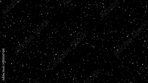 Snowflakes gently in dark winter sky. black background