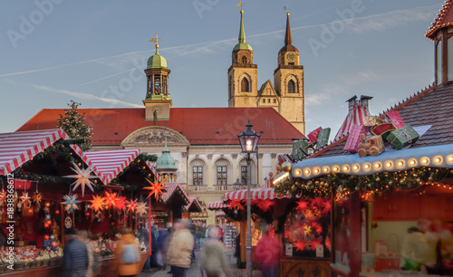 christmas market at the Old Market in Magdeburg, Germany, Saxony-Anhalt, time lapse with motion blur of people in the golden hour