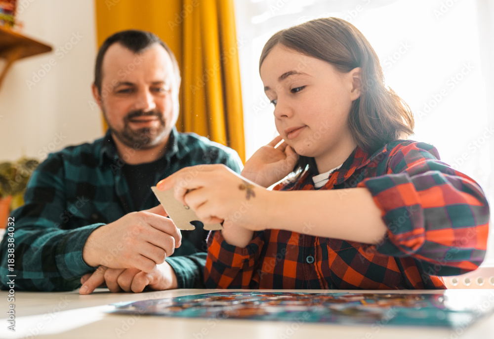 Fototapeta premium Father and daughter doing puzzle at home.
