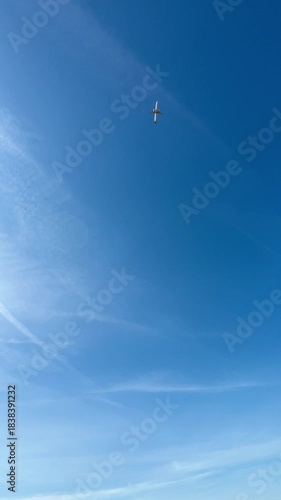 4K vertical wide angle video of passenger aircraft cruising in sky on bright sunny cloudless day. Transportation concept, ecology. Porto, Portugal