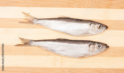 Herring fish isolated on a wooden cutting board