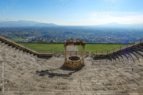 A well in the center of a staircase overlooking the landscape of the province of Rome,in Palestrina, Italy