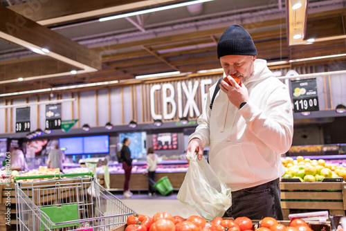 Man shopping in supermarket. Choosing food on grocery store shelf