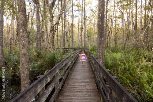 Child Walks Along Boardwalk in Six Mile Cypress Slough Preserve in Fort Myers During Afternoon