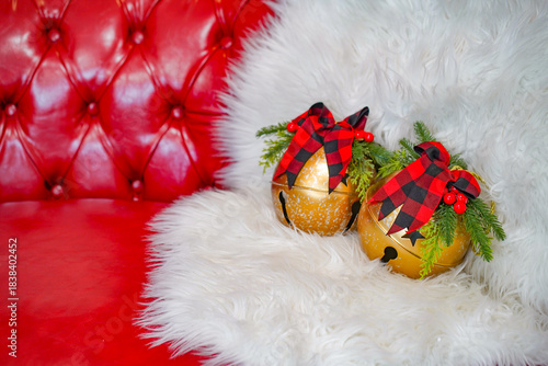 白いファーと赤いソファに置かれたクリスマスベルの装飾／Christmas bell decorations on white fur and red sofa