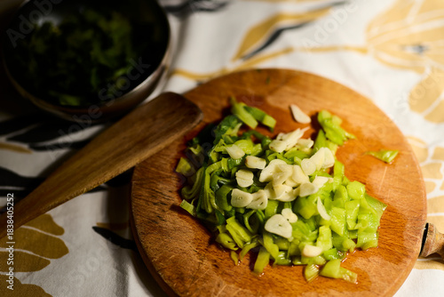 Leek and garlic. Cutting board with chopped leek and several cloves of garlic. There's also a bowl with some cilantro.