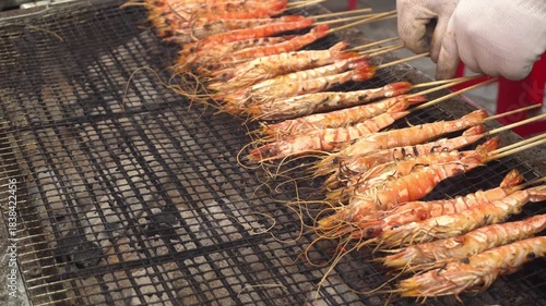 Freshly caught shrimps cooked on the grill. Seafood on skewers at the Asian market.	