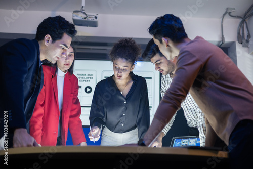 Diverse team of developers and designers having project discussion and strategy meeting. Reviewing digital data, brainstorming UX UI and web design for application development. Startup teamwork