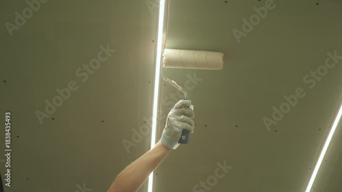 Priming the plasterboard ceiling with a roller