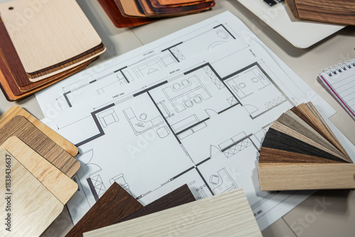 Interior design color palette with house floor plan and wood texture samples on desk