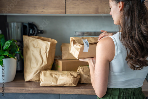 Photography Woman holding a labeled grocery bag with the word Recept, meaning recipe in another language