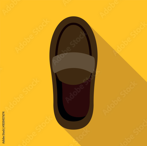 Brown loafer shoe with shadow on a yellow uniform background