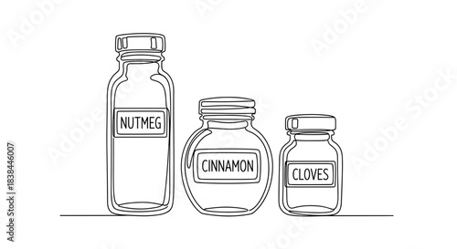 Three glass spice jars labeled nutmeg, cinnamon, and cloves  