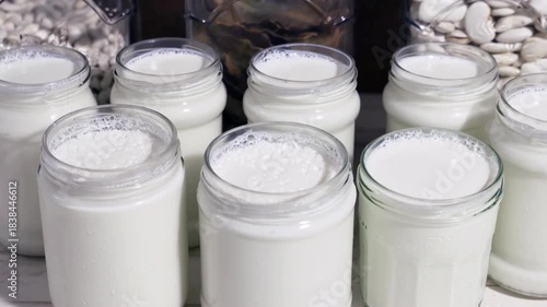 natural yoghurt in glass jars handmade at home fermenting milk with lactobacillus creating a probiotic to take care of the health of our intestine, 4k food video footage 
