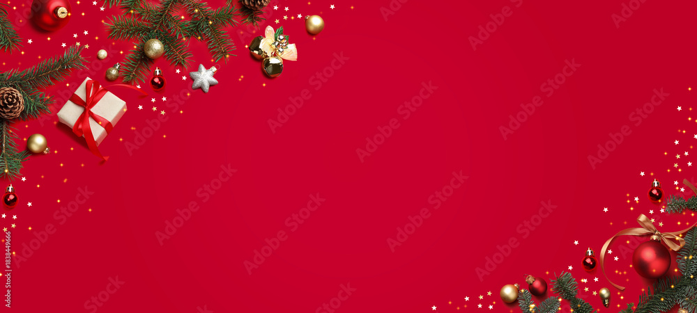 Fototapeta premium Christmas balls, gift box, fir branches and confetti on red background, top view. Greeting card or poster with space for text