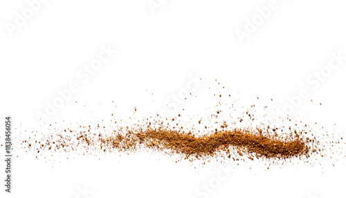 A small heap of brown sand, flecked with color, against a deep black background