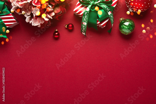 Merry Christmas and Happy Holidays greeting card, frame, border. New Year. Red Christmas ornaments and gifts, presents on red background top view. Xmas holiday festive theme. Christmas decoration